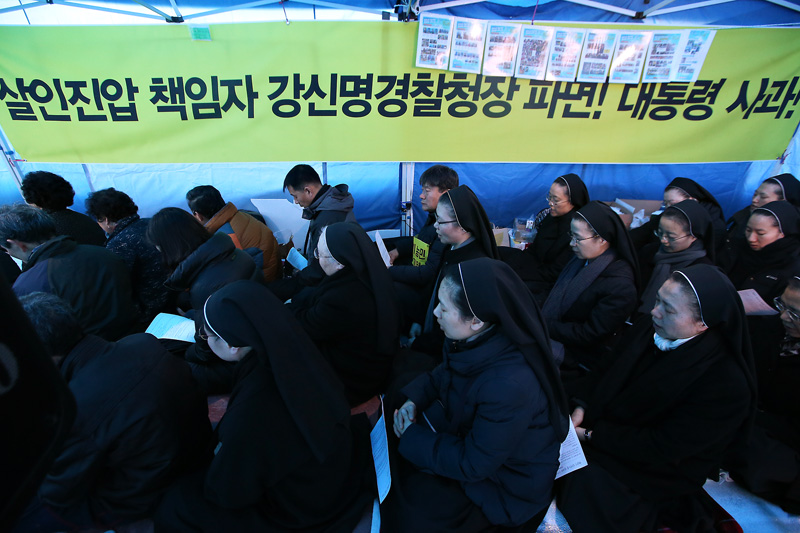 25일 오후 서울 종로구 서울대병원 앞 백남기 농민 쾌유 기원 농성장에서 열린 성탄대축일 미사에서 참석자들이 백남기 농민의 쾌유와 경찰의 물대포 살수에 대한 진상규명 및 책임자 처벌을 요구하고 있다.