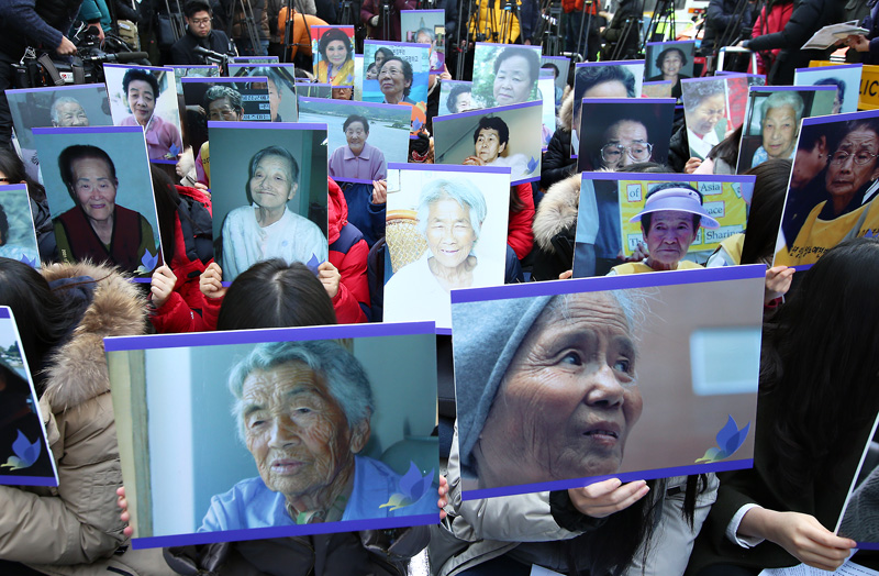 지난달 30일 오후 서울 종로구 일본대사관 앞에서 한일 위안부 문제 협상 타결 이후 처음 열린 수요집회에서 참가자들이 세상을 떠난 위안부 피해 할머니들의 사진을 들고 있다.