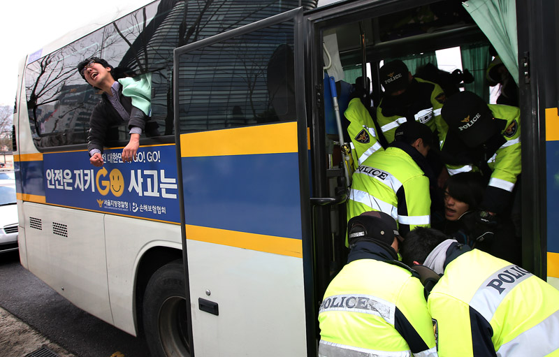 대학생들이 31일 오전 서울 종로구 일본대사관에서 한일 일본군 위안부 협상을 규탄하며 기습시위를 벌이다 경찰 버스로 연행되고 있다.