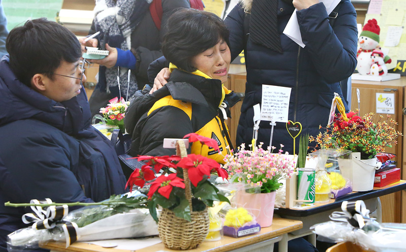 세월호 참사 생존학생 등 단원고 3학년 학생들의 졸업식이 열린 12일 오후 경기도 안산시 단원고등학교 3학년 명예교실에서 세월호 유가족이 자녀의 빈자리에 앉아 눈물을 흘리고 있다.