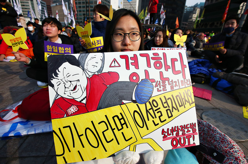30일 오후 서울광장에서 열린 한일 위안부 합의 폐기 촉구 5차 토요시위에서 참석자들이 한일합의 규탄 피켓을 들고 있다.