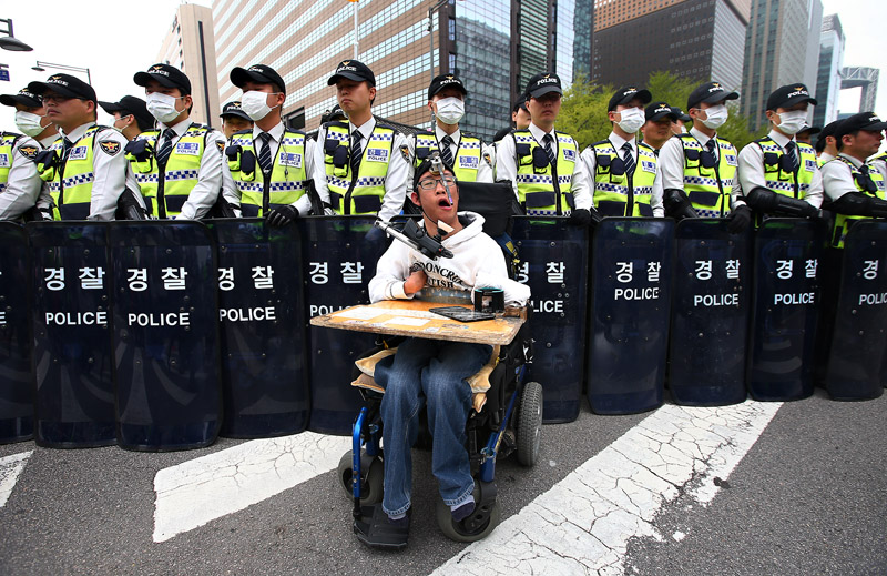 20일 오후 서울 광화문광장에서 열린 420 장애인차별철폐 투쟁결의대회 참가자들이 행진 중 경찰에게 원활한 행진 보장을 요구하고 있다.