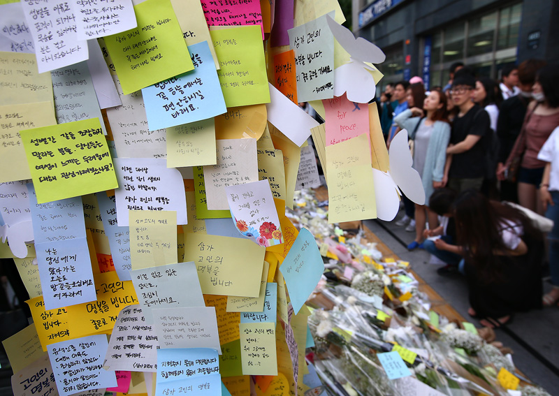 21일 오후 서울 강남역 10번 출구 앞에서 강남역 인근 남녀 공용 화장실에서 살해된 여성을 추모하고 있는 시민들