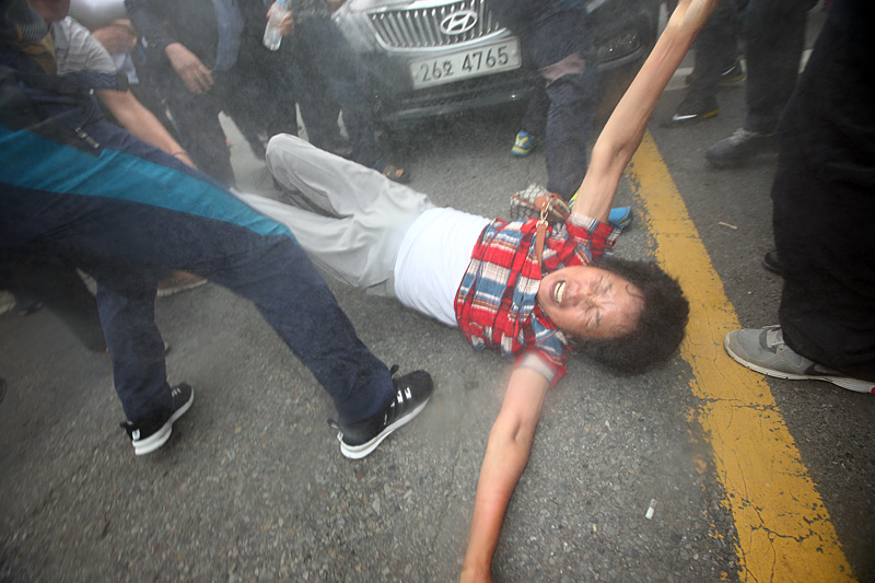 15일 오후 경북 성주군에서 주민이 사드 배치 철회를 요구하며 황교안 국무총리의 차를 몸으로 막다 끌려나가고 있다.