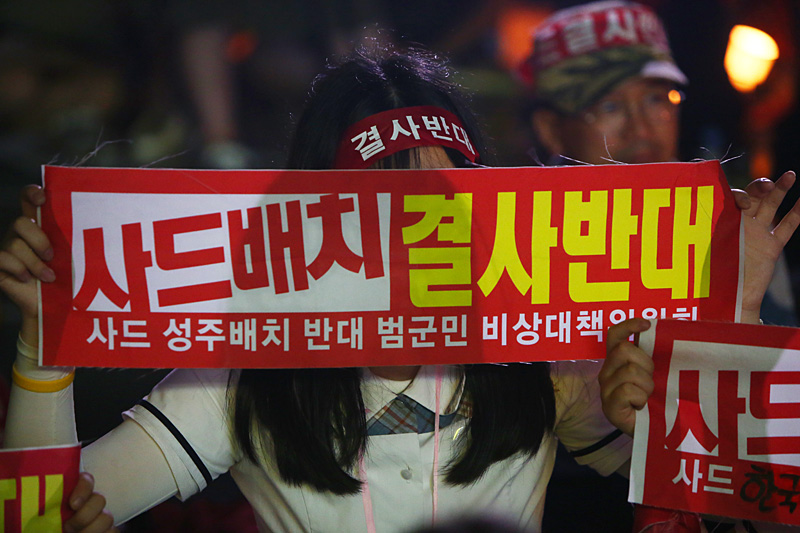 15일 오후 경북 성주군청 앞에서 열린 사드 배치 반대 촛불집회에서 여학생이 피켓을 들고 있다.