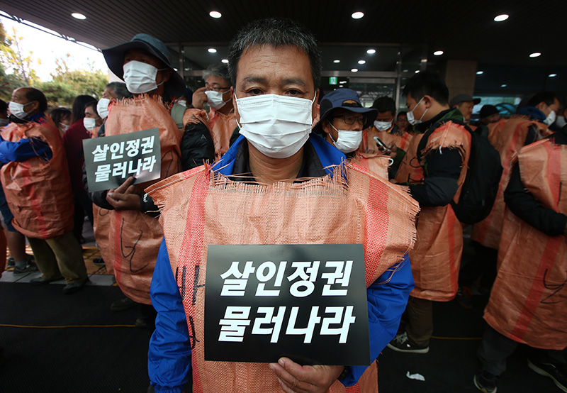 25일 오후 서울 종로구 서울대병원 장례식장에서 농민들이 피켓을 들고 백남기 농민 부검 집행을 반대하고 있다.