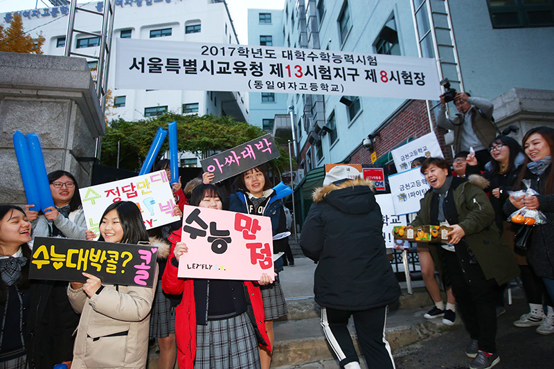 2017년도 대학수학능력시험일인 17일 오전 서울 금천구 동일여자고등학교 시험장 앞에서 재학생들이 응원전을 펼치며 도착하는 수험생들을 응원하고 있다.