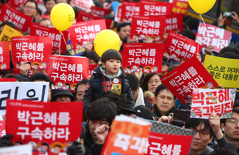 3일 오후 서울 종로구 청와대 사랑채 앞에서 청와대 인간띠잇기에 나선 시민들이 박근혜 대통령의 퇴진을 촉구하는 가운데 한 아이가 아버지의 어깨에 올라있다.