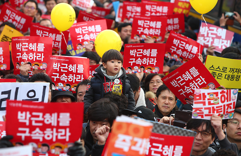 3일 오후 서울 종로구 청와대 사랑채 앞에서 청와대 인간띠잇기에 나선 시민들이 박근혜 대통령의 퇴진을 촉구하는 가운데 한 아이가 아버지의 어깨에 올라있다.