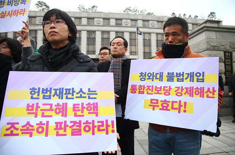 19일 오후 서울 종로구 헌법재판소 앞에서 '통합진보당 해산 2년 청와대 헌법재판소 커넥션 규탄 기자회견'이 열린 가운데 참가자들이 피켓을 들고 있다.
