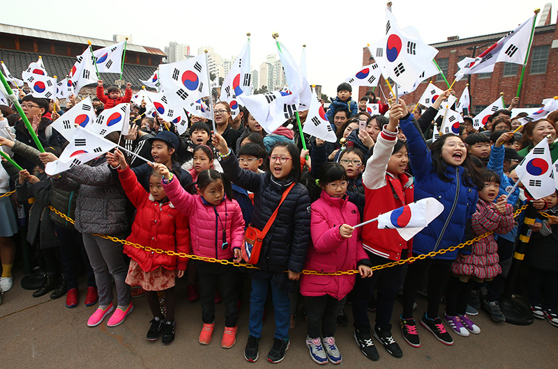 서대문형무소 역사관에서 지난해 열린 제98주년 3.1절 ‘1919 그날의 함성’ 기념행사에서 참가자들이 태극기를 흔들며 만세운동을 재연하고 있다.