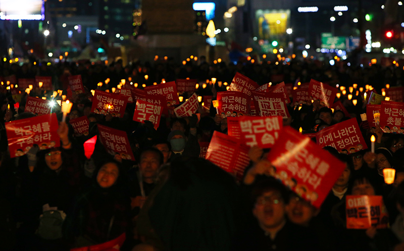 박근혜 대통령이 탄핵된 10일 오후 서울 광화문광장에서 열린 탄핵 기념 촛불집회에서 참가자들이 '촛불 승리' 피켓을 들고 박근혜 구속을 외치고 있다.