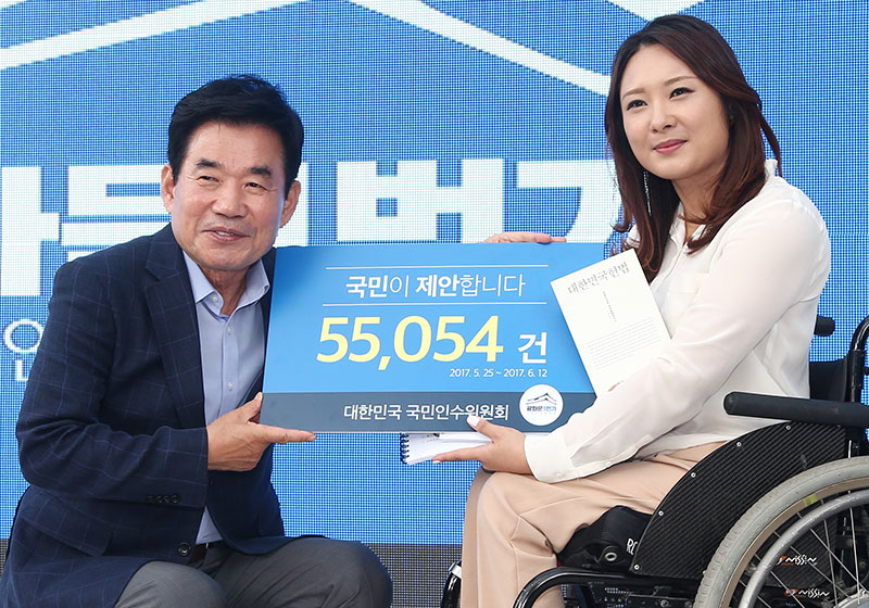 김진표 국정기획자문위원장이 17일 오후 광화문 세종로 광화문1번가 열린광장 국민인수위 국민경청보고서 전달식에서 홍서윤 소통위원(오른쪽)에게 보고서를 받고 있다.
