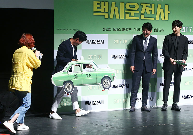 배우 유해진이 20일 오전 서울 압구정 CGV에서 열린 영화 '택시운전사' 제작보고회에서 택시 피켓을 들고 배우 송강호-류준열과 함께하고 있다.