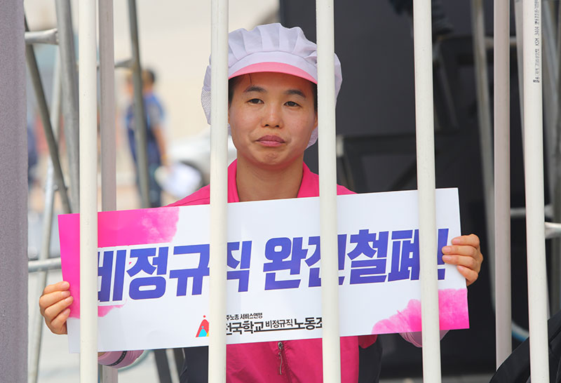 지난해 6월 30일 서울 광화문광장에서 전국학교비정규직노동조합이 연 총파업대회에서 무기한 비정규직 감옥에 갇힌 조합원이 피켓을 들고 있다.