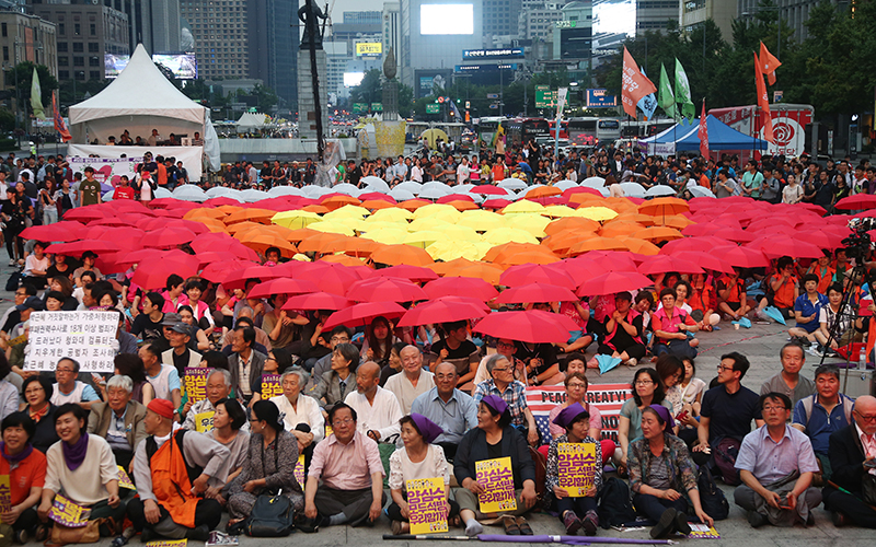 8일 오후 서울 광화문광장에서 열린 민주주의와 인권을 위한 양심수석방문화제에서 촛불의 힘으로 감옥문을 열자! 1000인 퍼포먼스를 진행하며 우산으로 촛불을 만들고 있다.