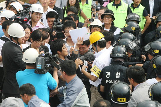 기자에 둘러싸인 법원 집행관
