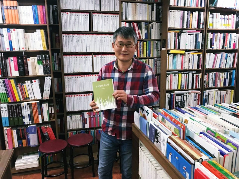 '풀무질' 책방 안에서 책을 들고 포즈 취하는 은종복 씨