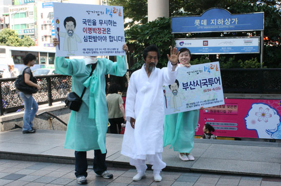 부산 서면 롯데백화점 앞에서 지나는 시민들을 향해 손을 흔드는 강기갑 대표.