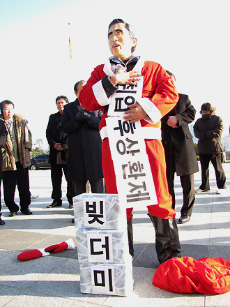 대학생들이 지난해 말 국회에서 기자회견 후 'MB가 취업 후 상환제라는 빚더미를 선물했다'는 내용의 퍼포먼스를 하고있다.