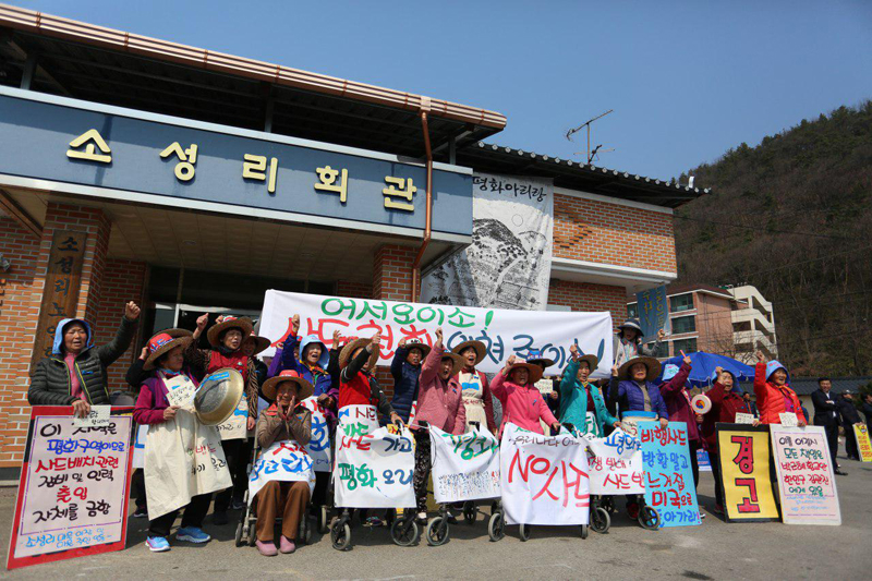 18일 주름이 자글자글한 60~80대 소성리 할머니 20여명은 파란리본이 그려진 밀집모자와 '우리 땅 우리가 지킨데이' 문구가 쓰인 앞치마를 두르고 평화버스 참가자들을 환영했다.