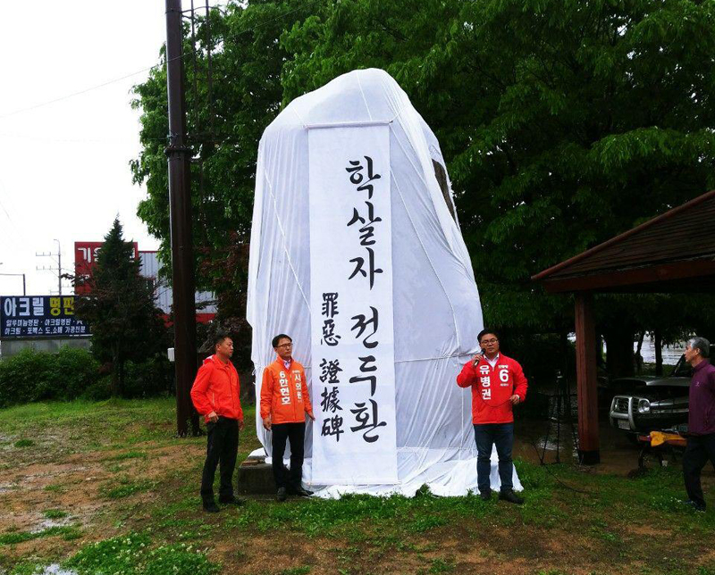 민중당 포천시지역위원회 관계자들은 17일 '전두환 공덕비'를 흰 천으로 가리는 퍼포먼스를 진행했다.