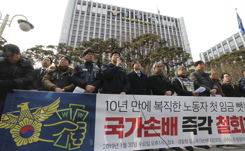 30일 서울 서대문구 경찰청 앞에서 열린 '쌍용차복직노동자에 대한 국가손배 임금가압류 규탄 기자회견'에서 임금가압류 당사자인 김정욱(왼쪽 다섯번째) 씨가 가압류 경과보고를 하고 있다. 이날 쌍용자동차 희생자추모 및 국가손배철회 범국민대책위원회를 비롯한 주최 측은 10년 만에 복직한 노동자의 첫 임금마저 빼앗는 경찰, 국가손배 즉각 철회를 촉구한다고 주장하며 쌍용차 노동자에 대한 손해배상가압류 철회 권고를 즉각 이행하라고 말했다. 2019.01.30.