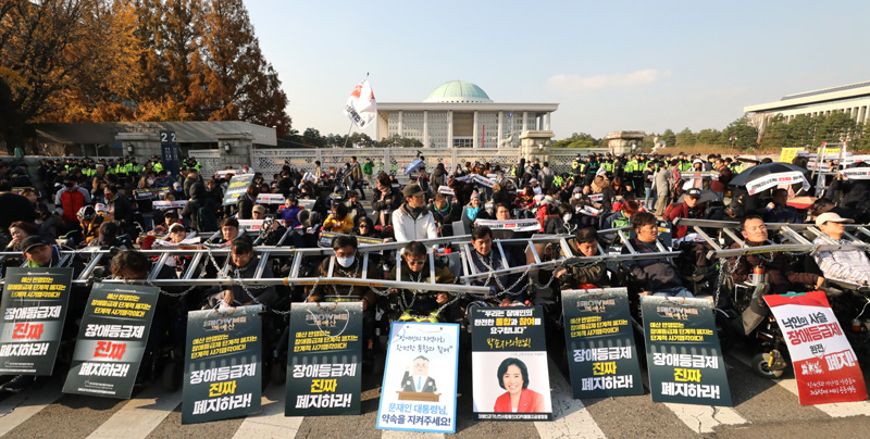 전국장애인차별철폐연대 등 장애인단체 회원들이 14일 오후 서울 여의도 국회 앞에서 몸에 쇠사슬을 두른채 장애등급제 폐지를 촉구하고 있다.