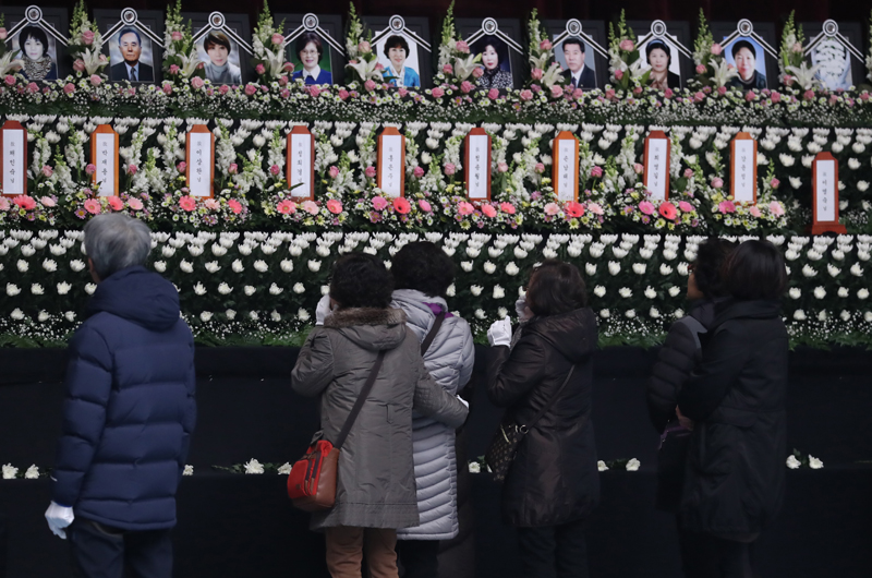 제천 스포츠센터 화재 사고 사흘째인 23일 오전 합동분향소가 마련된 충북 진천체육관에서 조문객들이 분향을 한 뒤 영정을 바라보고 있다. 2017.12.23.