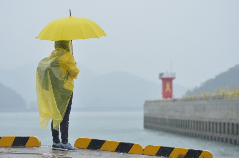 7일 오전 전남 진도군 임회면 팽목항에서 열린 세월호 선체 수중촬영 발표 기자회견에 앞서 한 세월호 유가족이 등대를 바라보고 있다.