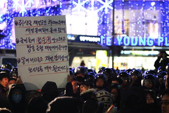 경찰에 포위된 시민이 피켓을 들어보이고 있다.