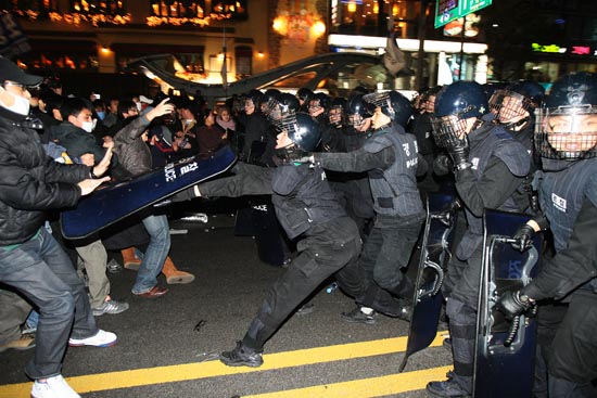 방패를 휘두르는 경찰