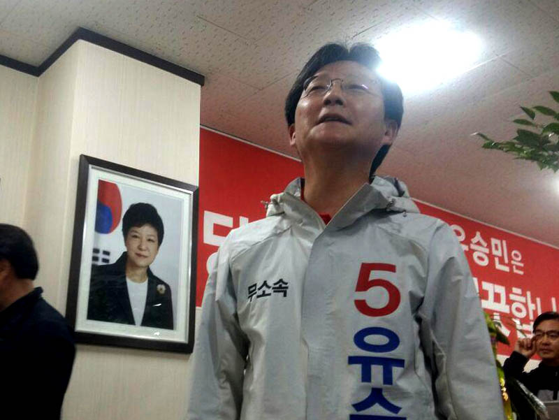 대구 동구을에 출마한 유승민(무소속) 의원이 30일 대구에 있는 자신의 선거사무소에서 개최한 선거대책본부 발대식에 앞서 지지자들을 만나고 있다. 유 의원 선거사무소 벽에는 논란의 중심에 있는 박근혜 대통령 사진이 그대로 걸려 있었다.