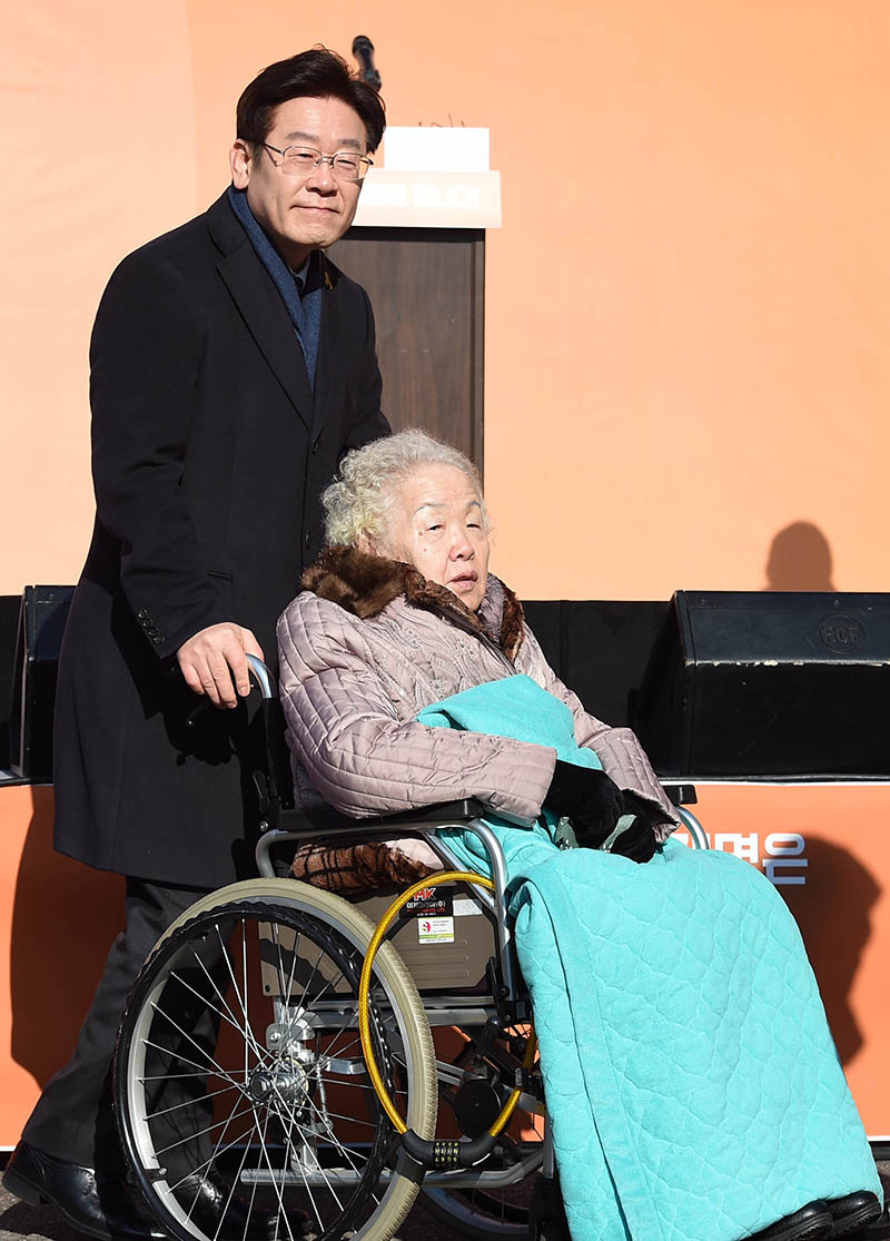 이재명 성남시장이 23일 오전 경기 성남 오리엔트 공장 앞마당에서 대선 출마 선언에 앞서 어머니와 함께 입장하고 있다.