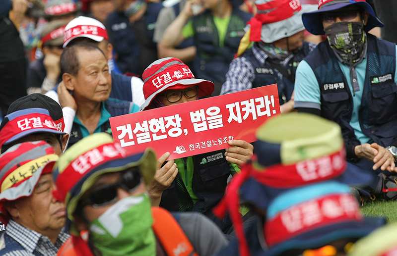 건설노조 조합원이 6일 오후 서울광장에서 열린 ‘건설노조 탄압 분쇄! 2016 총파업 투쟁 승리! 건설노동자 총력투쟁 결의대회’에서 피켓을 들고 있다.