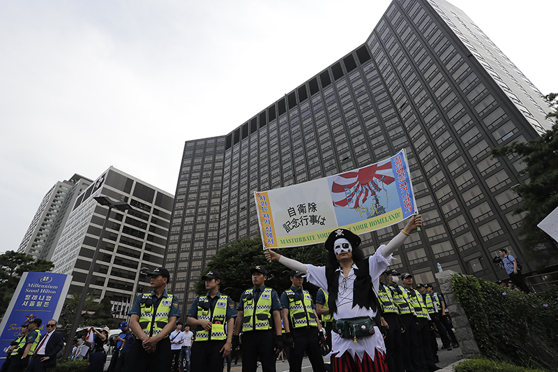 12일 오후 자위대 창설 62주년 기념행사가 열리는 서울 중구 밀레니엄 서울힐튼 앞에서 자위대 기념행사를 반대하는 시민이 피켓을 들고 있다.
