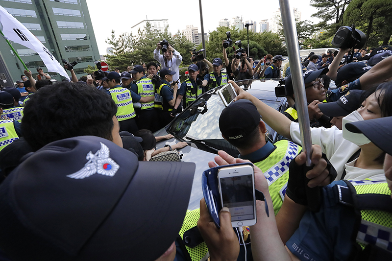 12일 오후 자위대 창설 62주년 기념행사가 열리는 서울 중구 밀레니엄 서울힐튼 앞에서 자위대 기념행사를 반대하는 시민단체가 행사장으로 들어오는 차를 몸으로 막고 있다.