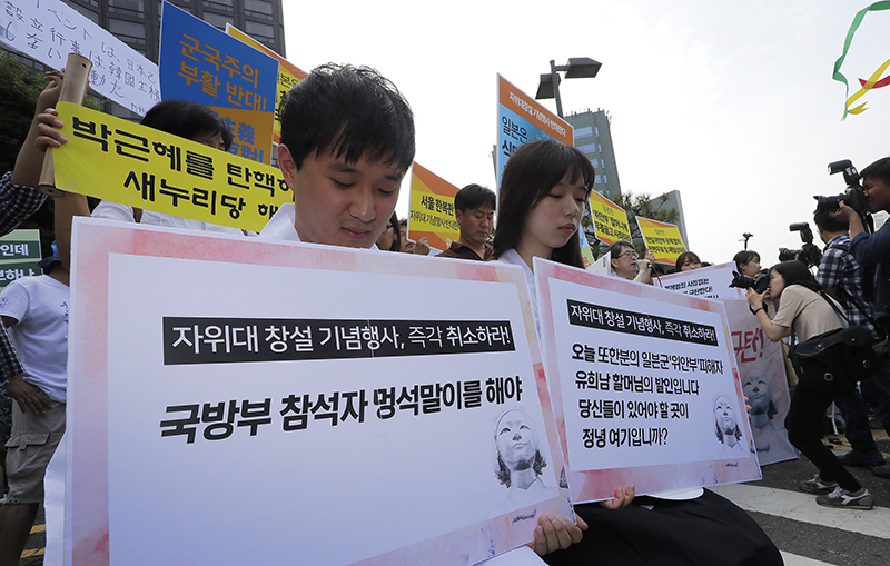 12일 오후 자위대 창설 62주년 기념행사가 열리는 서울 중구 밀레니엄 서울힐튼 앞에서 자위대 기념행사를 반대하는 시민단체가 피켓을 들고 있다.