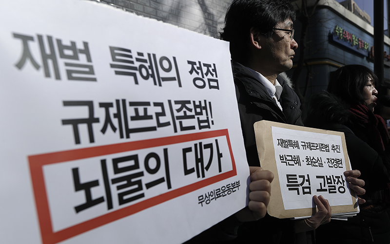 참여연대 등 시민단체 회원들이 1월 23일 오후 서울 강남구 대치동 특검사무실 앞에서 열린 '재벌특혜 규제프리존법 추진한 박근혜-최순실-전경련 특검 고발 기자회견’에서 피켓을 들고 있다.