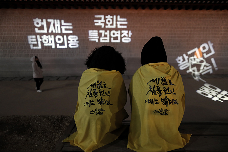 25일 오후 서울 광화문광장에서 열린 박근혜 대통령 퇴진을 촉구하는 17차 촛불집회에 참가한 세월호 유가족들이 광화문 앞에 앉아있다.