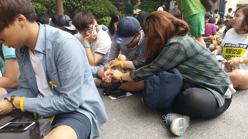 행진에 참여한 학생들이 서로에게 노란리본을 묶어주고 있다.