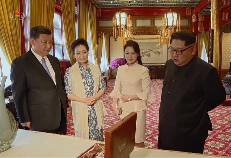 북한 조선중앙TV가 29일 방중한 김정은 노동당 위원장과 부인 리설주가 시진핑 중국 국가주석과 부인 펑리위안 여사에게 자신들이 준비한 선물을 소개하는 모습을 공개하고 있다. 2018.03.29.