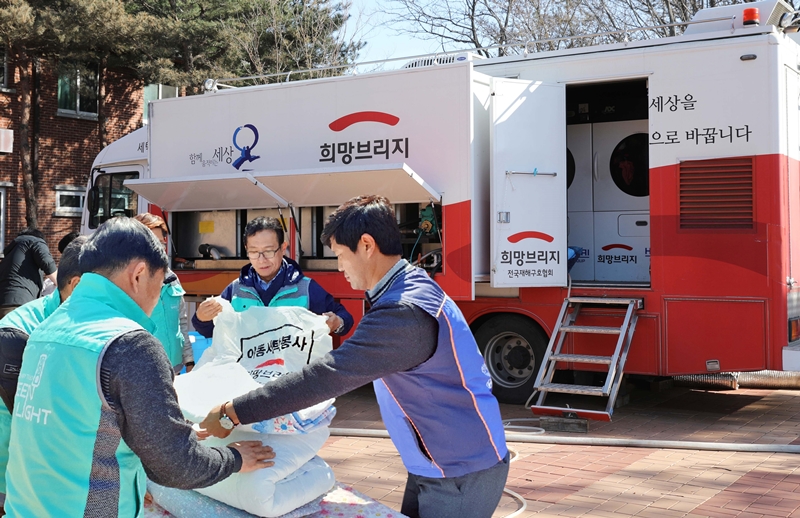 현대·기아차 임직원들이 강원도 산불 피해 지역에 투입된 현대차그룹의 ‘도시형 세탁구호차량’과 함께 세탁 봉사를 하고 있는 모습.