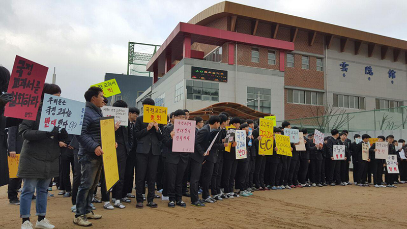 2일 오전 입학식이 진행되는 경북 경산의 문명고등학교 강당 앞에서 신입생과 학부모들이 국정교과서 철회를 촉구하는 피켓 시위를 벌이고 있다.