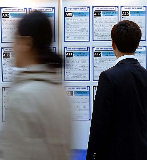 한 청년이 취업 게시판에 적힌 공고 문구를 바라보고 있다.