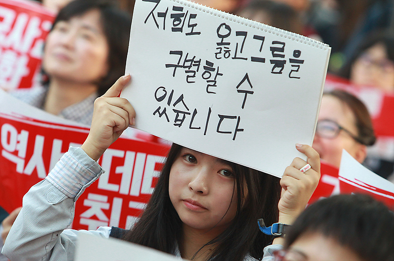 17일 서울 세종로 세종공원에서 열린 한국사교과서 국정화 저지 국민대회에 참가한 중학생이 국정화를 반대하는 손피켓을 들고 있다.