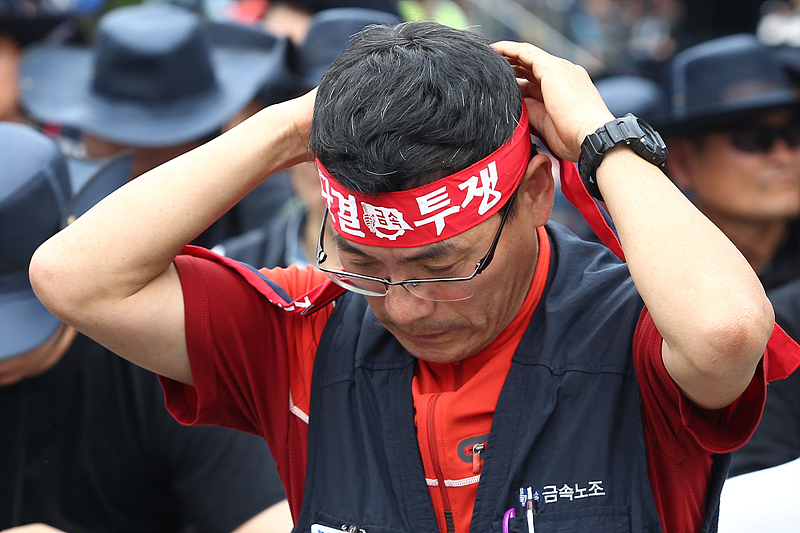 22일 서울 여의도 산업은행 본점 앞에서 열린 ‘금속노조 총파업 결의대회’에 참석한 조합원이 머리띠를 묶고 있다.