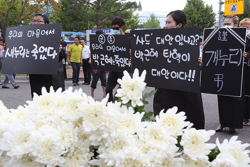 26일 경북 성주군 성주군청 앞에서 열린 ‘새누리당 장례식’에서 박근혜 대통령의 탄핵과 근조 개누리라고 적힌 손피켓을 들고 있다.
