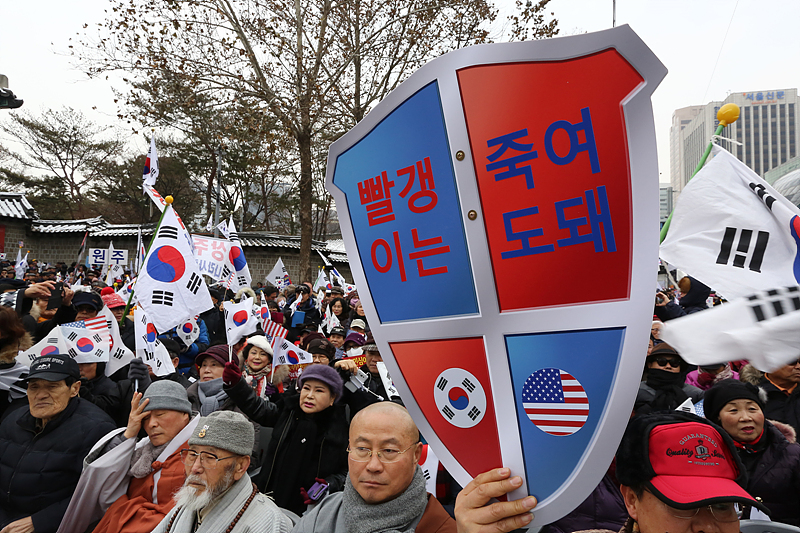 21일 서울 중구 대한문 앞에서 열린 박사모의 탄핵반대 집회에 참석한 박사모 회원이 발갱이는 죽여도 된다는 손피켓을 들고 있다.