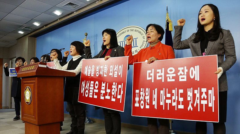 새누리당 전국여성의원협의회가 25일 국회 정론관에서 표창원 더불어민주당 의원 주최 시국비판 풍자 전시회에 전시됐던 박근혜 대통령 풍자 그림 ‘더러운 잠’을 비판하며 표 의원의 부인을 벗기겠다는 성희롱 문구가 담긴 손피켓을 들고 있다.